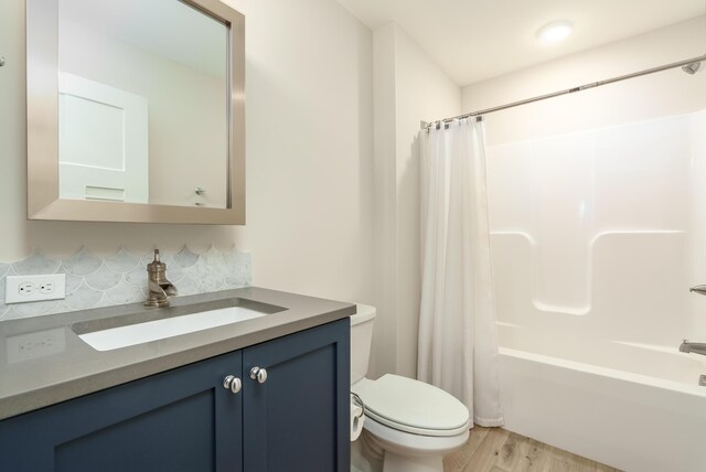 6606 Spaniel Dr, Kalamazoo, MI 49009 - bathroom with toilet, vanity, shower / tub combo with curtain, wood finished floors, and backsplash