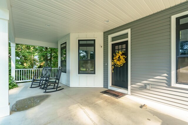 6606 Spaniel Dr, Kalamazoo, MI 49009 - view of exterior entry featuring covered porch and board and batten siding
