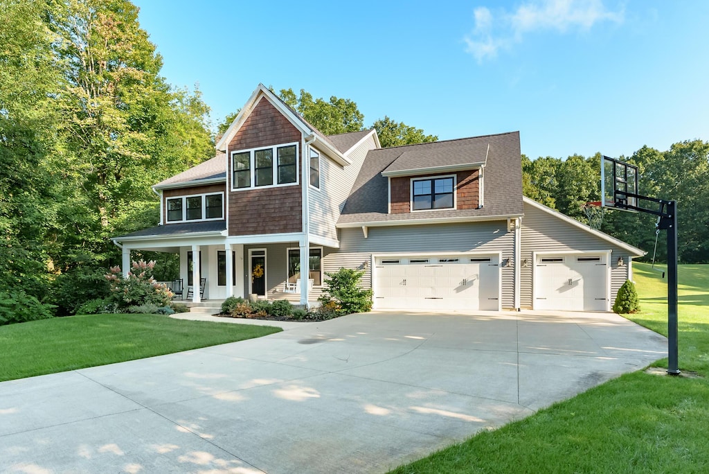 6606 Spaniel Dr, Kalamazoo, MI 49009 - shingle-style home with a porch, a front yard, driveway, and roof with shingles