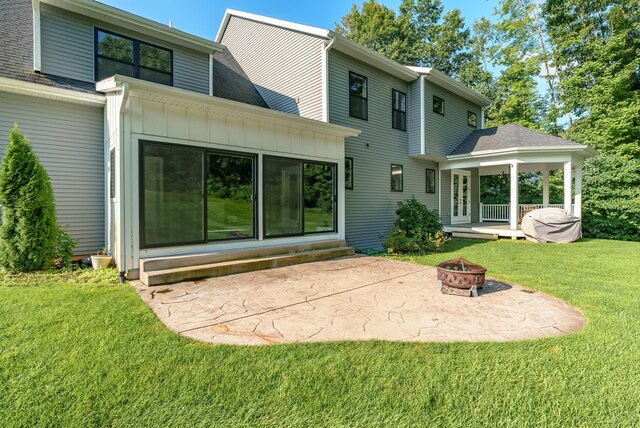 6606 Spaniel Dr, Kalamazoo, MI 49009 - rear view of property with an outdoor fire pit, a patio area, a yard, board and batten siding, and entry steps