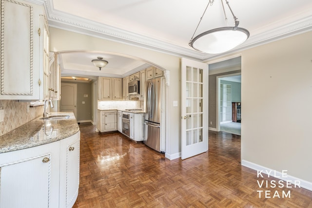 600 Plymouth Ave SE, East Grand Rapids, MI 49506 - kitchen featuring stainless steel appliances, arched walkways, a sink, crown molding, and tasteful backsplash