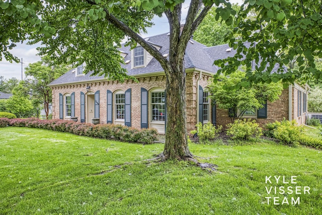 600 Plymouth Ave SE, East Grand Rapids, MI 49506 - view of front facade with brick siding, a front yard, and roof with shingles