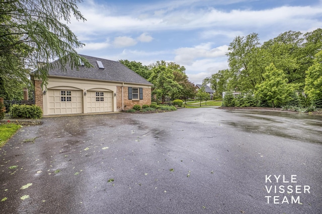 600 Plymouth Ave SE, East Grand Rapids, MI 49506 - view of front of house featuring asphalt driveway, roof with shingles, an attached garage, and brick siding