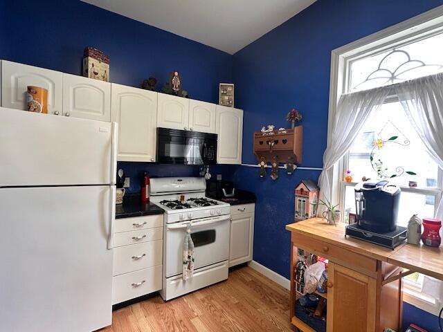 6 Vine St, Hillsdale, MI 49242 - kitchen with white appliances, white cabinetry, light wood-style floors, and lofted ceiling