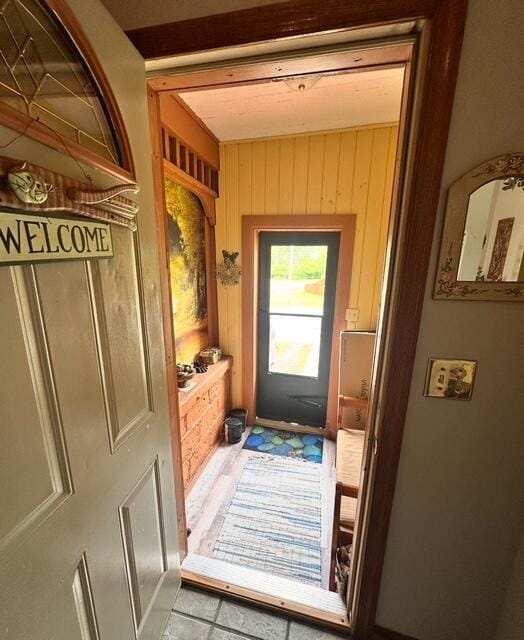 6 Vine St, Hillsdale, MI 49242 - doorway to outside with wooden walls and tile patterned flooring