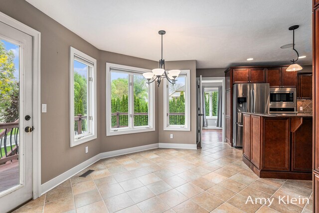 1657 N Bay Dr, Hudsonville, MI 49426 - kitchen with stainless steel appliances, a chandelier, baseboards, decorative light fixtures, and light tile patterned floors
