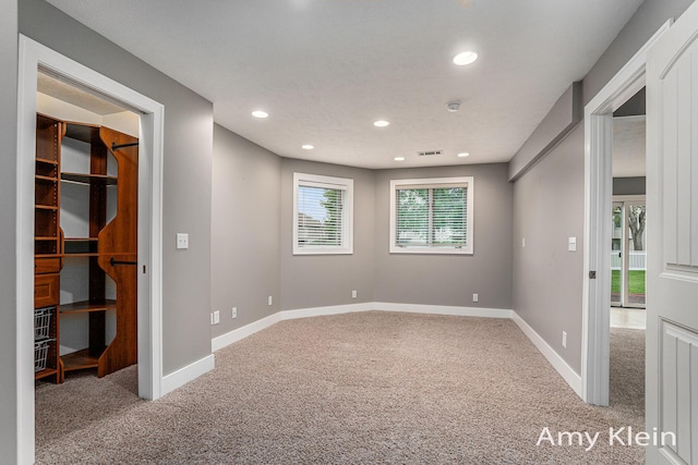 1657 N Bay Dr, Hudsonville, MI 49426 - unfurnished bedroom with carpet flooring, a walk in closet, recessed lighting, and baseboards