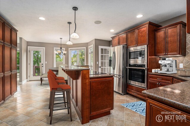 1657 N Bay Dr, Hudsonville, MI 49426 - kitchen featuring appliances with stainless steel finishes, tasteful backsplash, recessed lighting, a center island, and a breakfast bar area