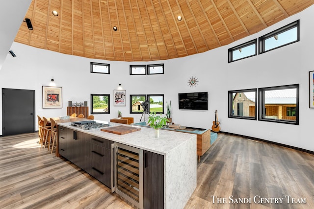 18619 130th Ave, Fruitport, MI 49415 - kitchen featuring high vaulted ceiling, wine cooler, stainless steel gas stovetop, wood ceiling, and light wood-style floors
