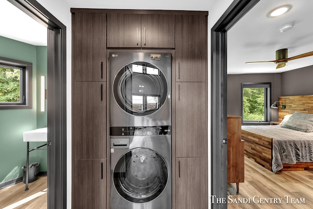 18619 130th Ave, Fruitport, MI 49415 - laundry room featuring cabinet space, estacked washer and dryer, light wood-style flooring, and ceiling fan