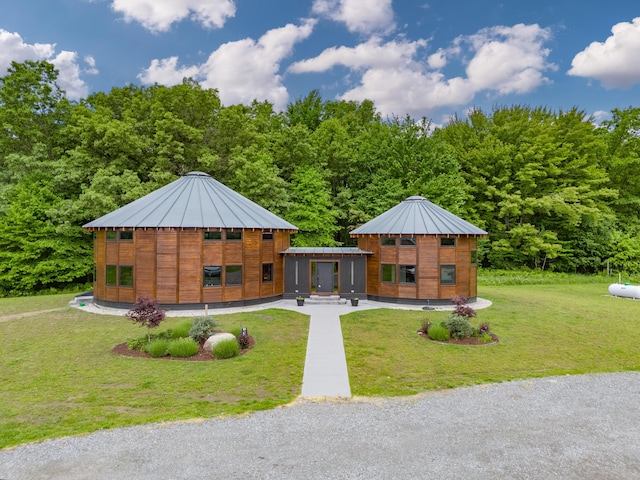 18619 130th Ave, Fruitport, MI 49415 - view of front of home with a front lawn, metal roof, a wooded view, and a standing seam roof