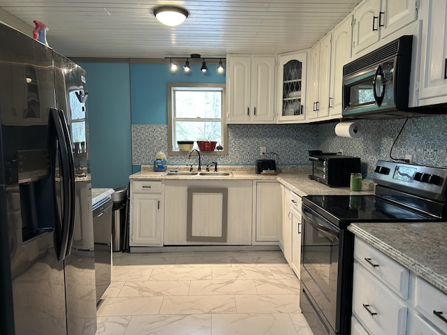 3092 S M 37, Baldwin, MI 49304 - kitchen featuring black appliances, a sink, light marble finish floors, tasteful backsplash, and rail lighting