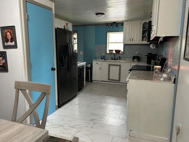 3092 S M 37, Baldwin, MI 49304 - kitchen featuring black fridge, light marble finish floors, stove, a sink, and backsplash