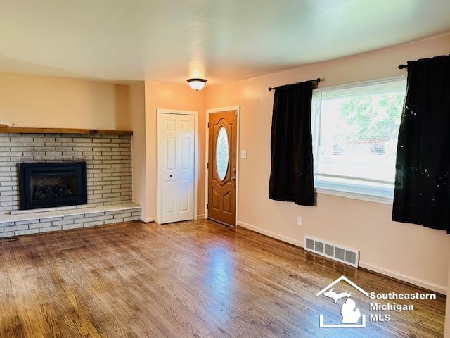 8499 Armstrong Rd, Newport, MI 48166 - foyer entrance featuring wood finished floors, a fireplace, and baseboards