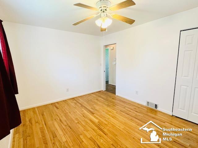 8499 Armstrong Rd, Newport, MI 48166 - unfurnished bedroom with light wood finished floors, baseboards, a closet, and ceiling fan