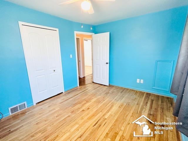 8499 Armstrong Rd, Newport, MI 48166 - unfurnished bedroom featuring wood finished floors, a closet, a ceiling fan, and baseboards