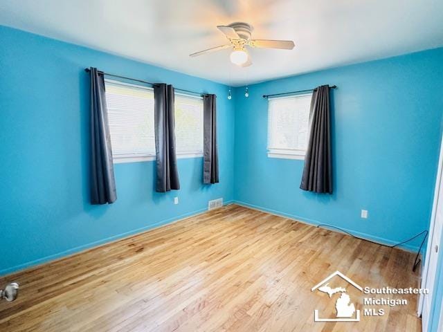 8499 Armstrong Rd, Newport, MI 48166 - empty room with wood finished floors, a ceiling fan, and baseboards