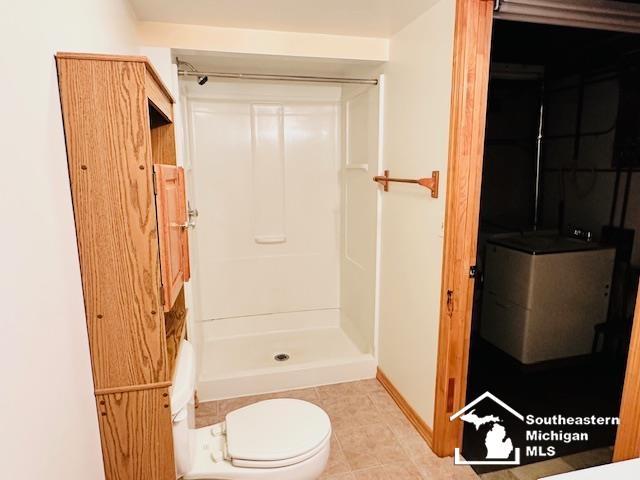 8499 Armstrong Rd, Newport, MI 48166 - full bathroom with a shower stall, tile patterned flooring, toilet, and baseboards