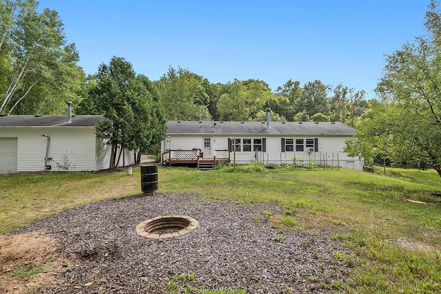 11478 E 7 Mile Rd, Tustin, MI 49688 - back of property featuring a fire pit, a deck, and a lawn
