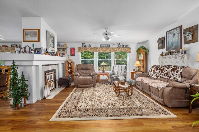 11478 E 7 Mile Rd, Tustin, MI 49688 - living area with a fireplace with flush hearth, wood finished floors, and ceiling fan