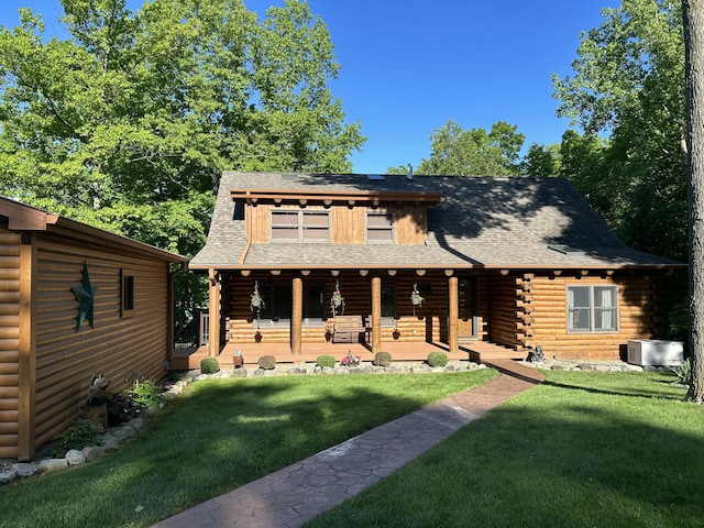 14278 Tyson Trl, Camden, MI 49232 - log-style house featuring log exterior, a front yard, and covered porch