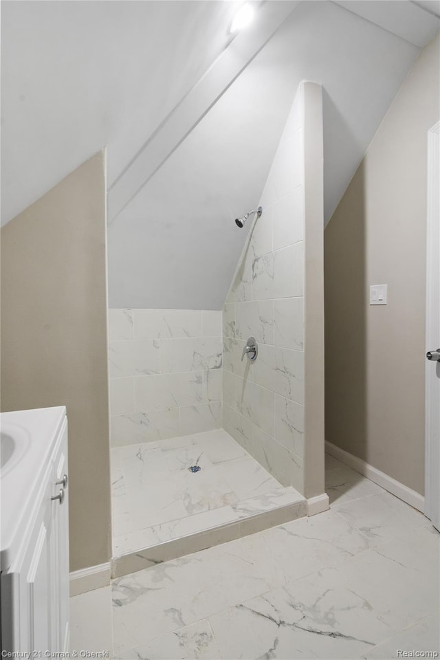 65 Melbourne St, Detroit, MI 48202 - bathroom with marble finish flooring, a tile shower, vaulted ceiling, vanity, and baseboards