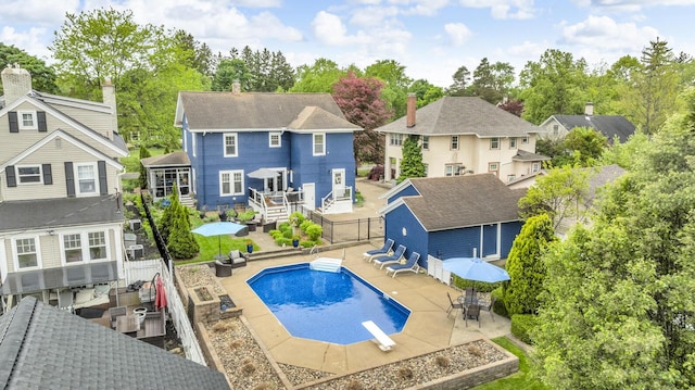 1406 W Washington Ave, Jackson, MI 49203 - rear view of property featuring a fenced backyard, a residential view, an outdoor pool, outdoor dining area, and an outdoor structure