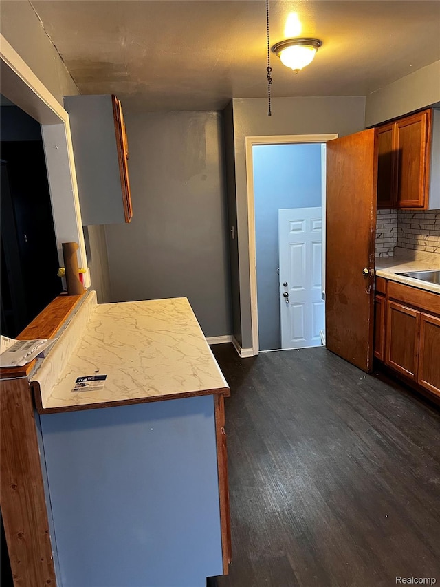 8208 Kentucky St, Detroit, MI 48204 - kitchen with dark wood finished floors, brown cabinetry, a peninsula, and light countertops
