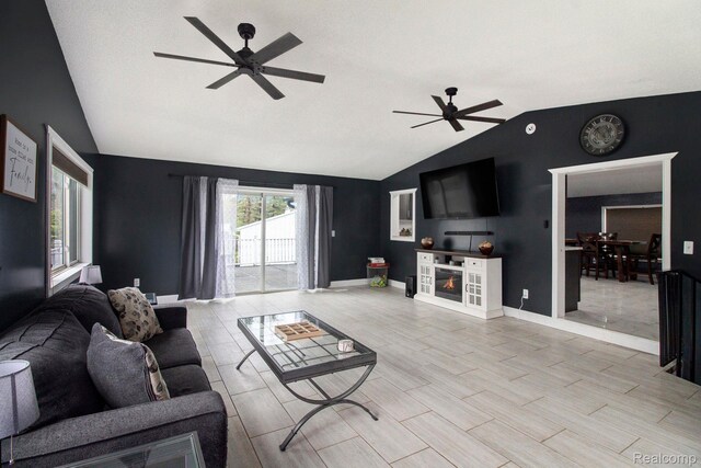 5315 Brown Rd, Millington, MI 48746 - living room featuring vaulted ceiling, a ceiling fan, a glass covered fireplace, and baseboards