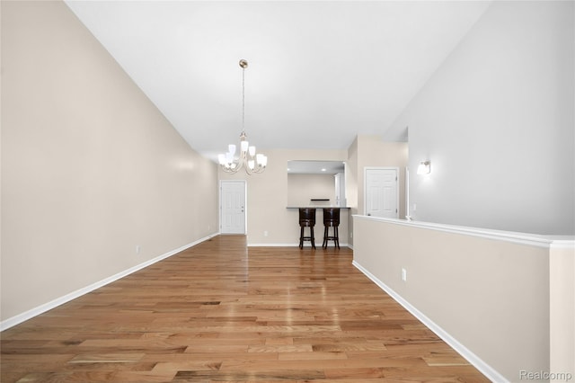 3021 Berkshire Rd, Auburn Hills, MI 48326 - unfurnished living room with a chandelier, baseboards, light wood-style flooring, and vaulted ceiling