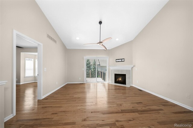 3021 Berkshire Rd, Auburn Hills, MI 48326 - unfurnished living room featuring ceiling fan, wood finished floors, a tiled fireplace, baseboards, and high vaulted ceiling
