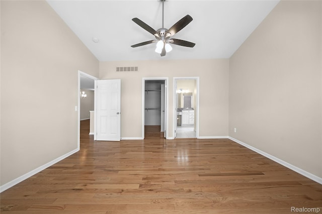 3021 Berkshire Rd, Auburn Hills, MI 48326 - unfurnished bedroom with baseboards, a spacious closet, wood finished floors, and vaulted ceiling