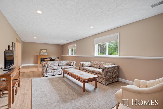 5348 Cristo Dr NE, Rockford, MI 49341 - living room with light wood-type flooring, a textured ceiling, recessed lighting, and baseboards