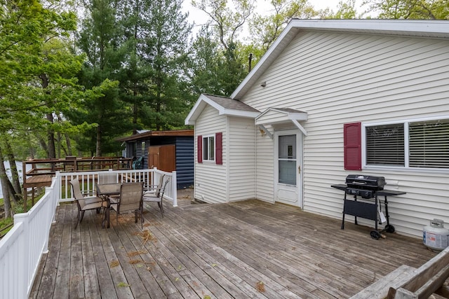10138 S Lakeside Ridge Rd, Baldwin, MI 49304 - wooden deck with outdoor dining area and a grill