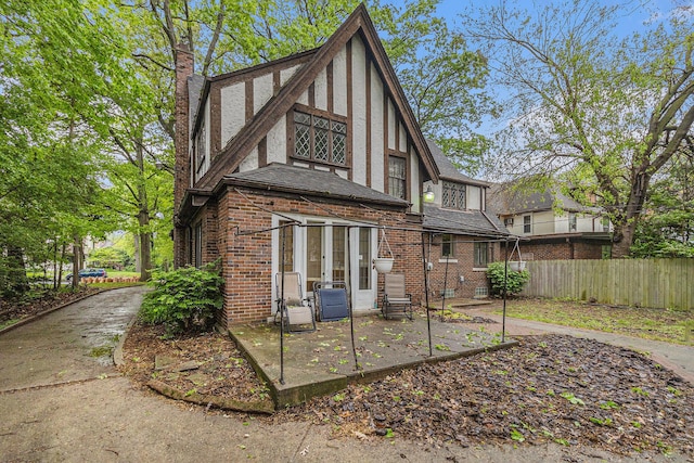 3261 Sherbourne Rd, Detroit, MI 48221 - rear view of property with a chimney, stucco siding, a patio area, brick siding, and french doors