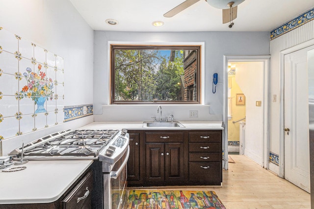 3261 Sherbourne Rd, Detroit, MI 48221 - kitchen featuring stainless steel range with gas cooktop, a sink, light wood-type flooring, dark brown cabinets, and light countertops