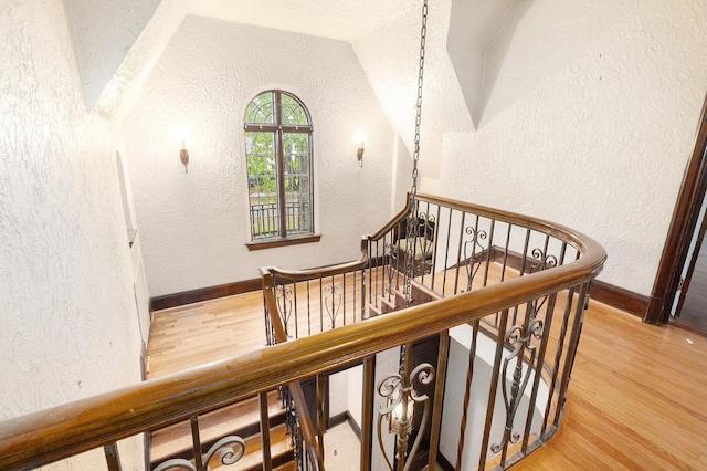 3261 Sherbourne Rd, Detroit, MI 48221 - stairs with a textured wall, wood finished floors, vaulted ceiling, and baseboards