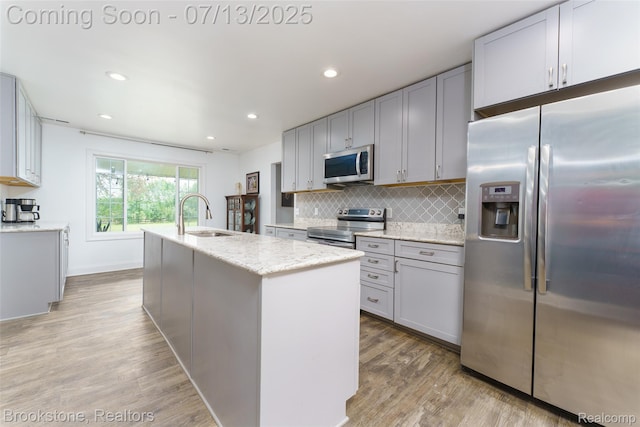 6245 Ray Rd, Swartz Creek, MI 48473 - kitchen featuring stainless steel appliances, light wood-style flooring, an island with sink, backsplash, and recessed lighting