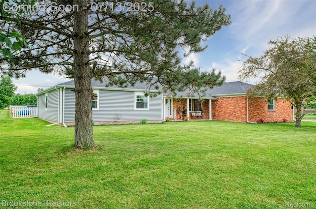 6245 Ray Rd, Swartz Creek, MI 48473 - rear view of property with a lawn, roof with shingles, covered porch, and brick siding