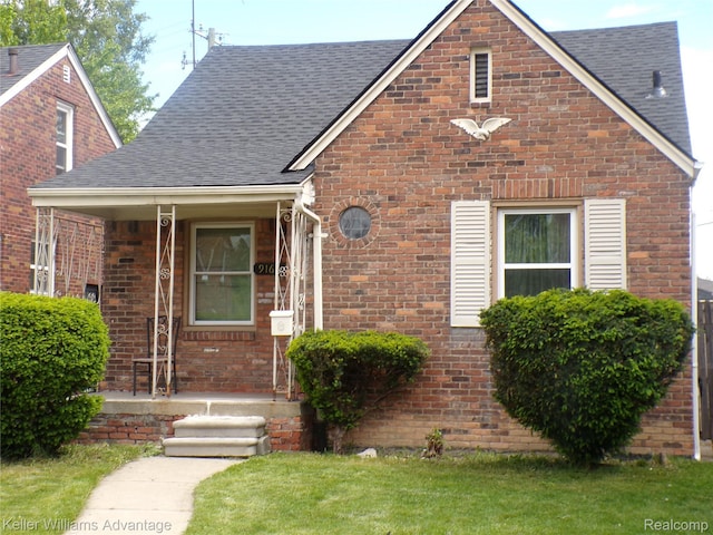9162 Audubon Rd, Detroit, MI 48224 - view of front of property with roof with shingles, covered porch, brick siding, and a front yard