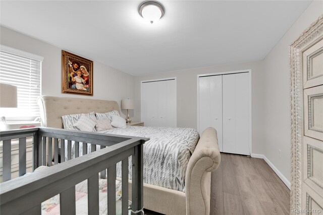 39321 Faith Dr, Sterling Heights, MI 48310 - bedroom featuring multiple closets, wood finished floors, and baseboards