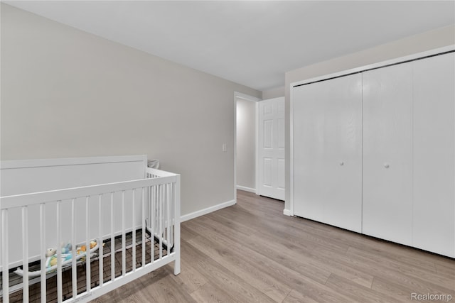 39321 Faith Dr, Sterling Heights, MI 48310 - bedroom featuring wood finished floors, a closet, baseboards, and a crib