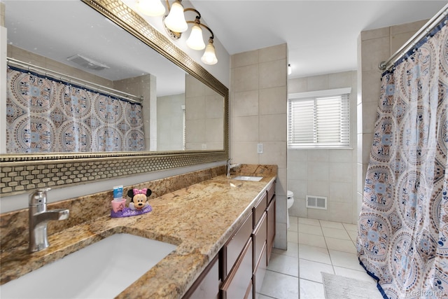 39321 Faith Dr, Sterling Heights, MI 48310 - bathroom featuring tile walls, double vanity, toilet, tile patterned floors, and a shower with shower curtain