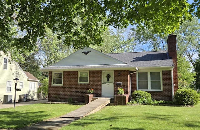 2204 Lakeway Ave, Kalamazoo, MI 49001 - bungalow-style house featuring a front lawn, a chimney, central AC, and brick siding