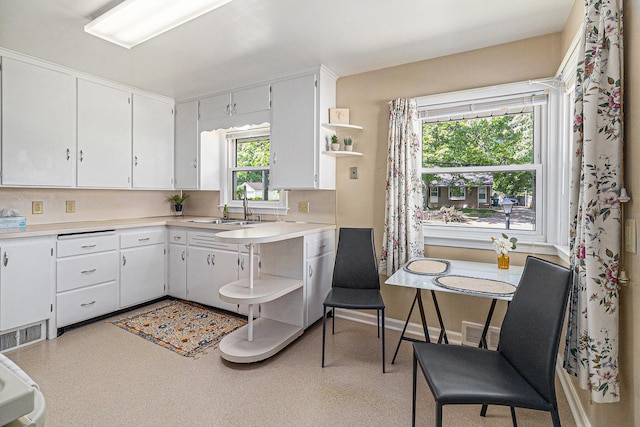 2204 Lakeway Ave, Kalamazoo, MI 49001 - kitchen with open shelves, a sink, light countertops, and white cabinets