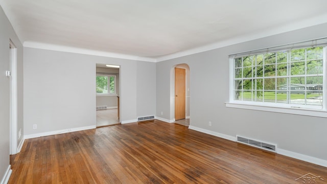 1355 Hemmeter Rd, Saginaw, MI 48638 - spare room featuring arched walkways, wood-type flooring, and baseboards