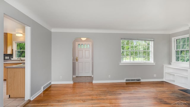 1355 Hemmeter Rd, Saginaw, MI 48638 - unfurnished living room with light wood-style floors, arched walkways, and baseboards