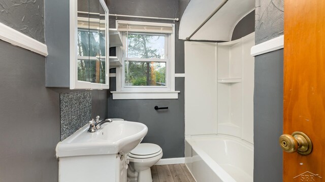1355 Hemmeter Rd, Saginaw, MI 48638 - full bathroom featuring toilet, vanity, baseboards, wood finished floors, and bathing tub / shower combination