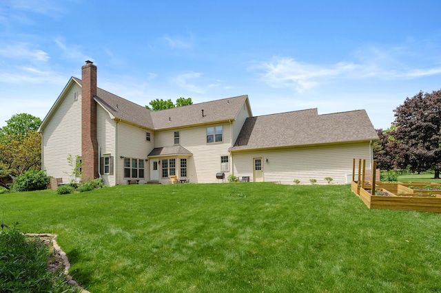 3638 Bellflower Dr, Portage, MI 49024 - rear view of house with a lawn, a chimney, a garden, and roof with shingles
