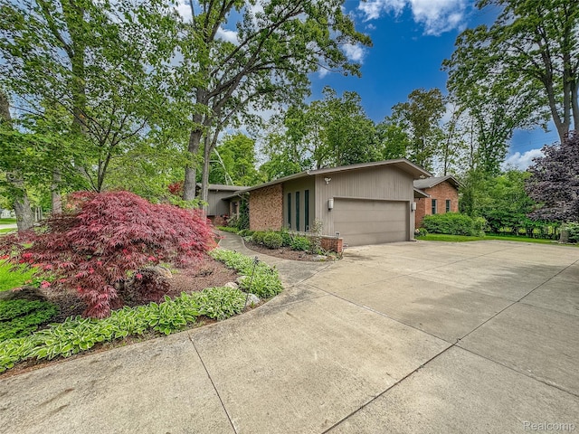 5259 Echo Rd, Bloomfield Hills, MI 48302 - view of front of property featuring brick siding, an attached garage, and concrete driveway